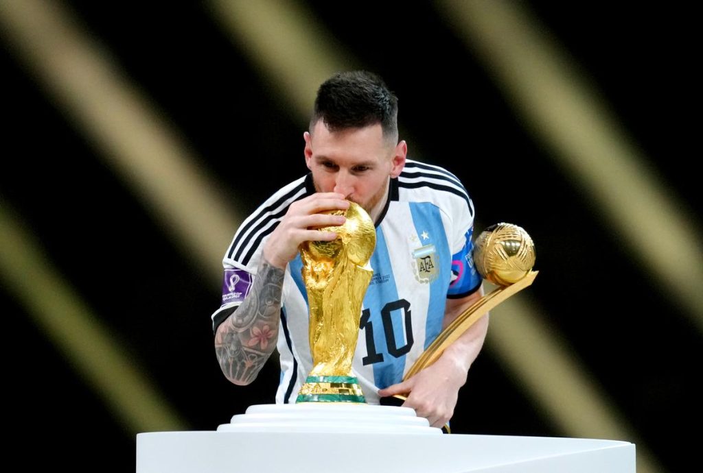 Argentina’s Lionel Messi kisses the FIFA World Cup trophy after being presented with the Golden